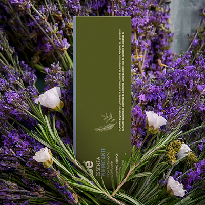 immagine del prodotto fiala essenza ambientata su sfondo con lavanda, rosmarino e fiori bianchi